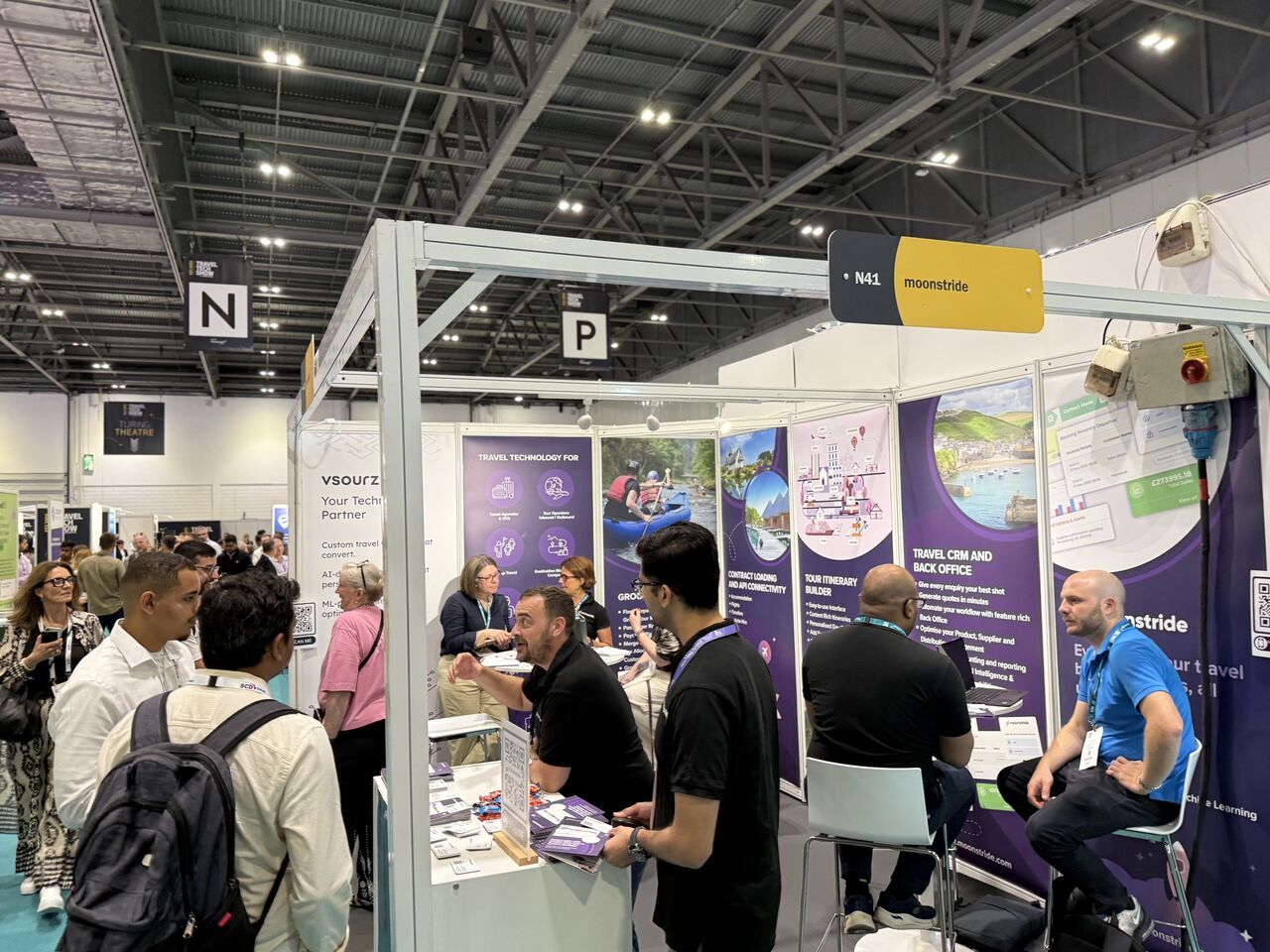 Visitantes viendo la Plataforma moonstride en acción en la pantalla de la caseta